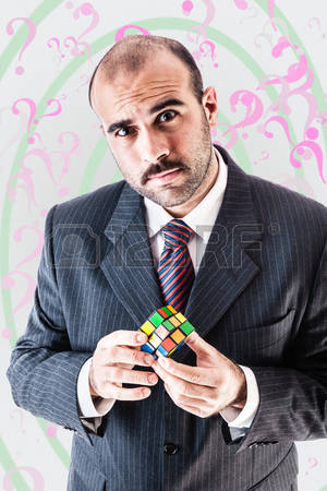 puzzled-businessman-trying-to-solve-a-puzzel-cube.jpg