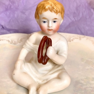 Figurine of a porcelain boy eating - front