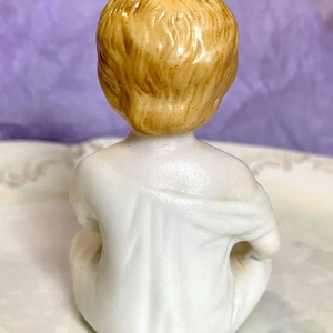 Figurine of a porcelain boy eating - back/reverse